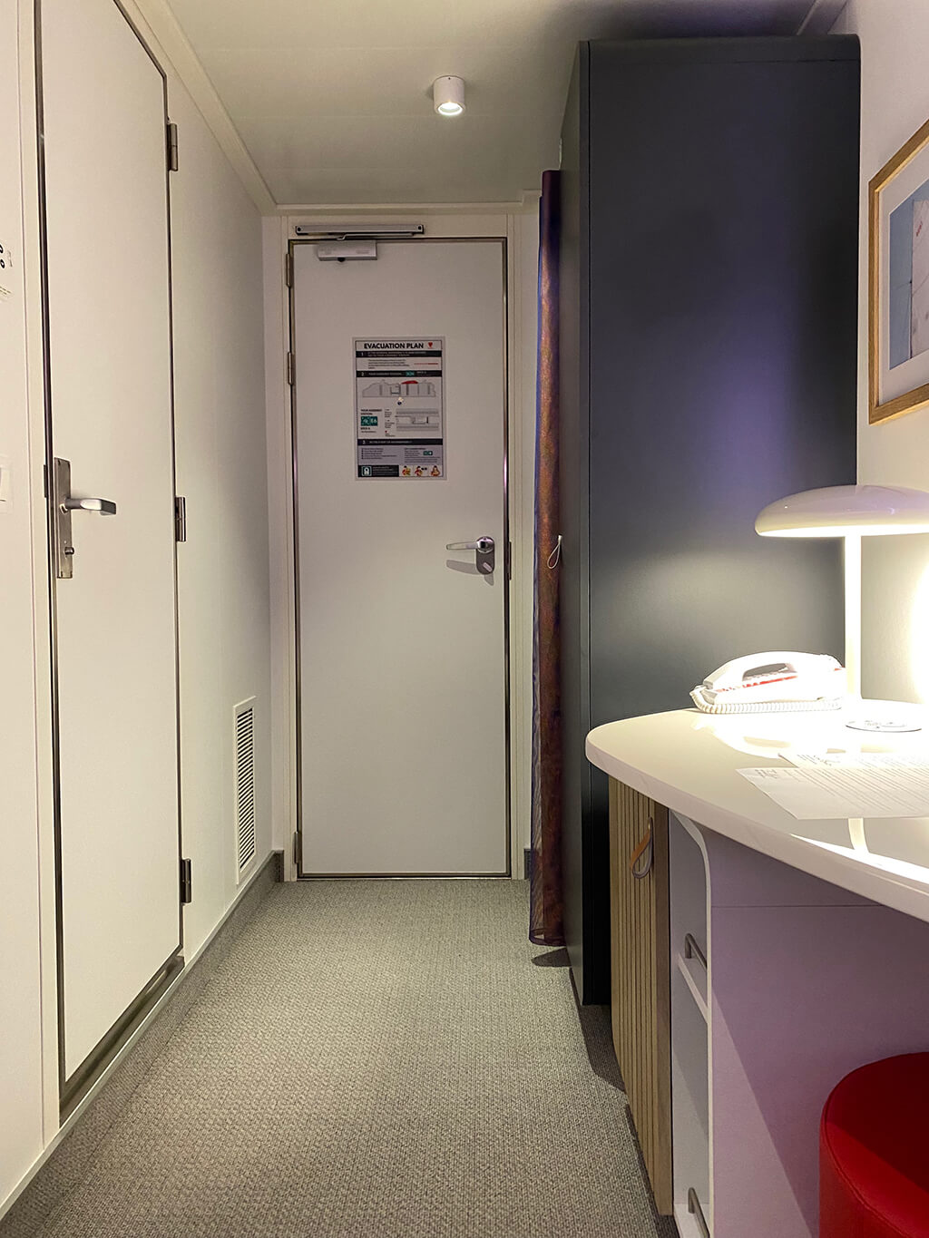 Image looking towards the entrance door from the end of the cabin on a Virgin Voyages ship.