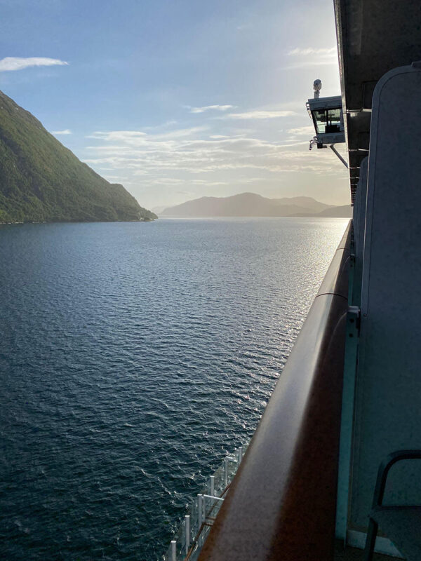 Image of the Norwegian Fjords from a cruise ship balcony. Mountains either side a body of water