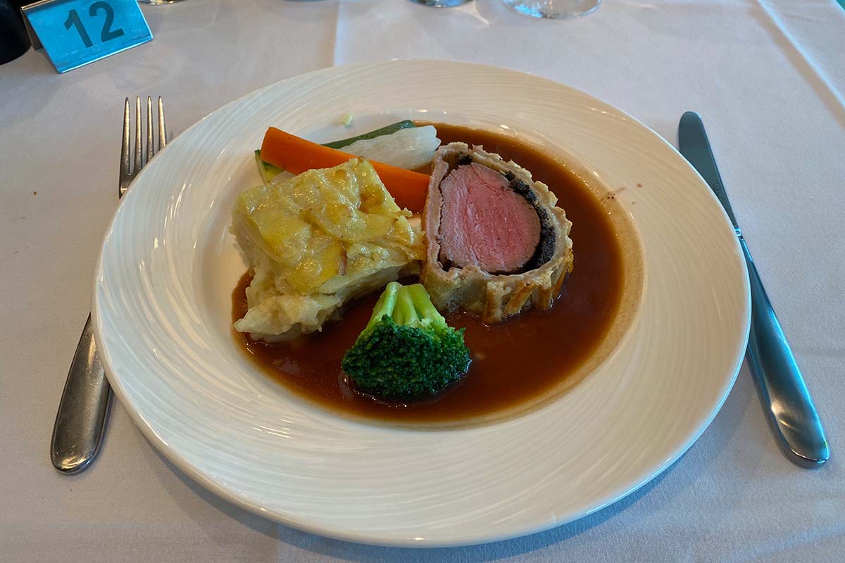 Beef Wellington, potato cake and broccoli on plate