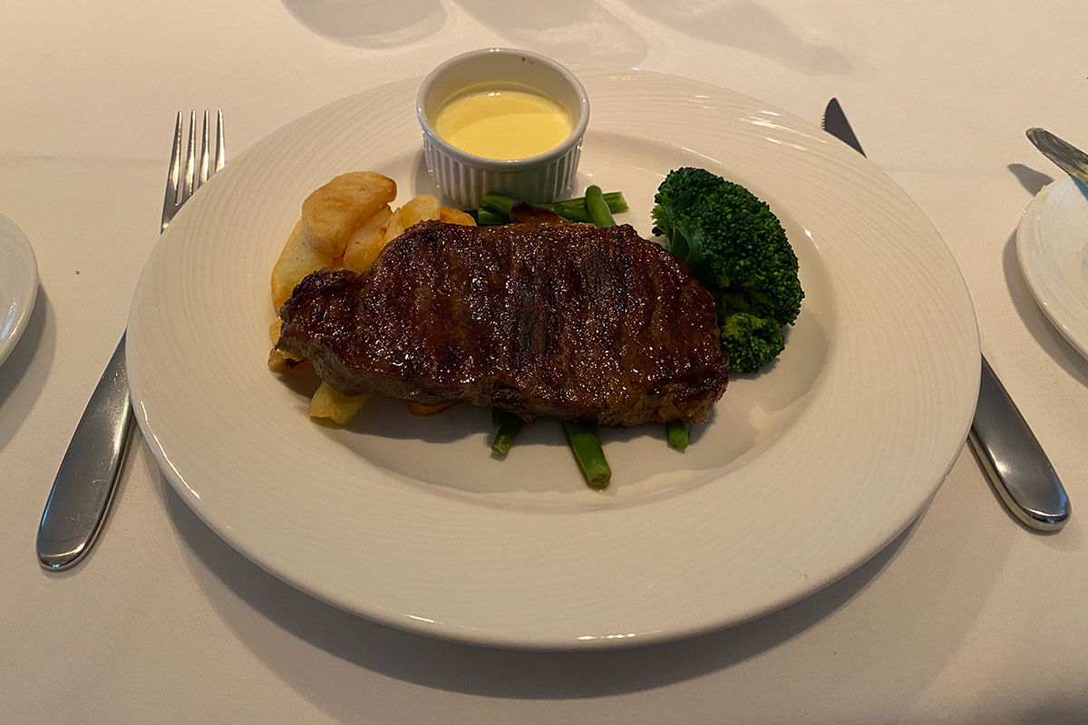 Steak, chips and broccoli on plate