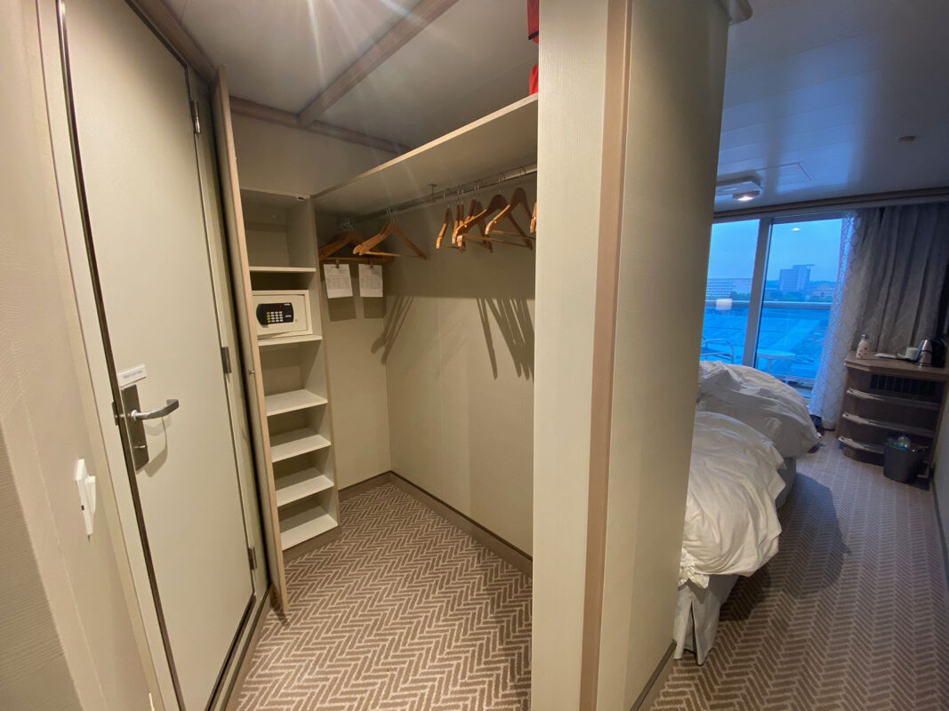 image of closet with long hanging rail and narrow cupboard with shelves in cruise ship cabin