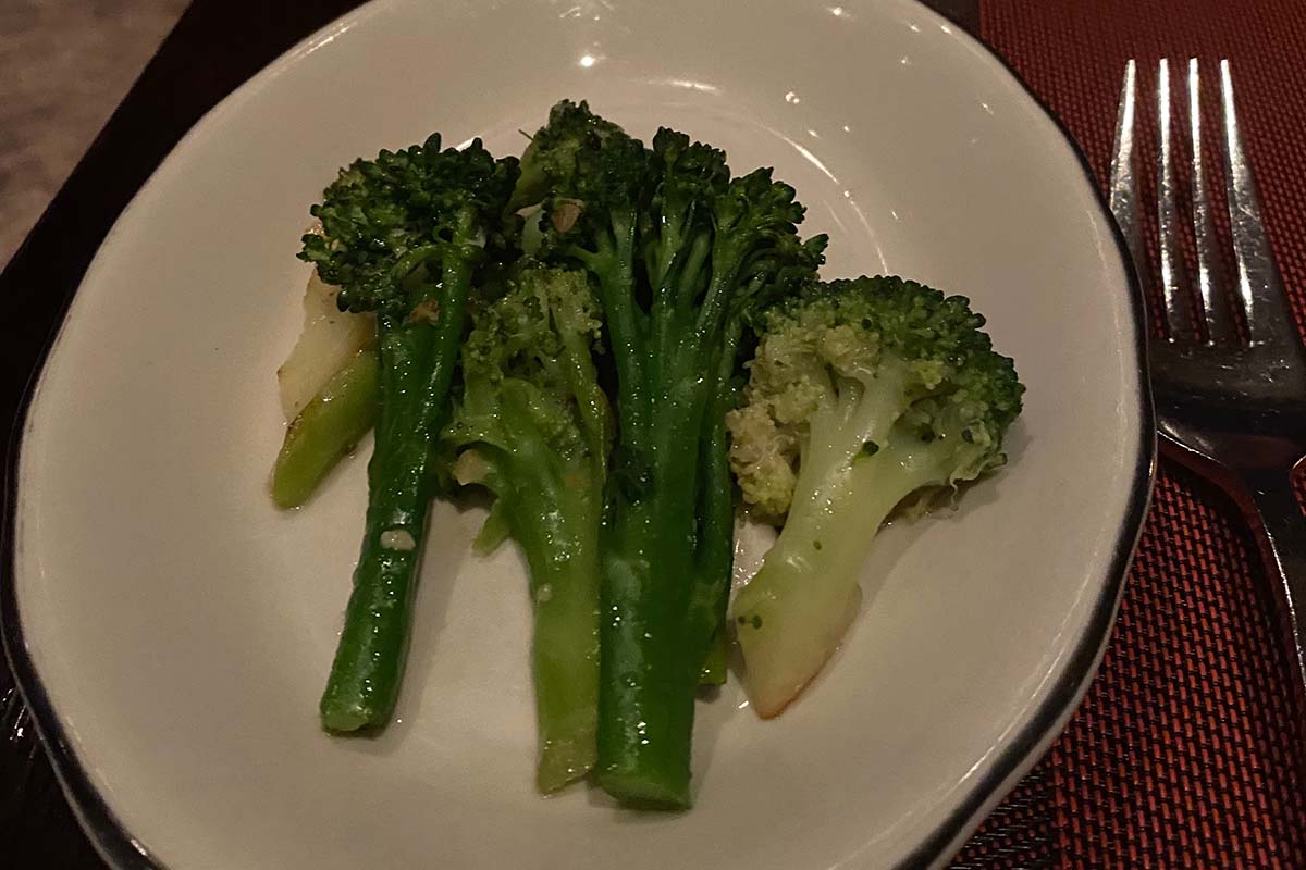 image of steamed broccoli steams on white plate