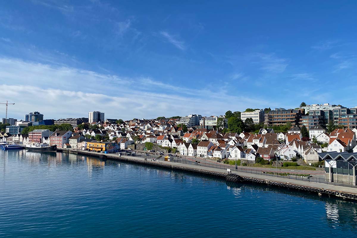 image of white wooden building of the old town in Stavanger next to more modern buildings.