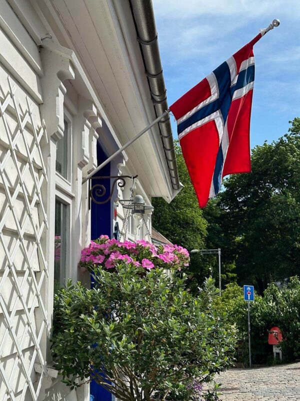 A Norwegian Flag flies outside a white wooden house in Gamle Stavanger, the old town in Stavanger