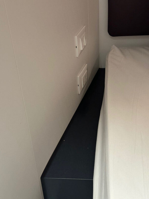 A small ledge next to at the bed in a Virgin Voyages Solo Insider cabin.